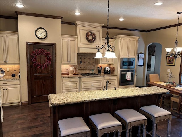 kitchen with pendant lighting, decorative backsplash, light stone countertops, dark hardwood / wood-style flooring, and stainless steel appliances