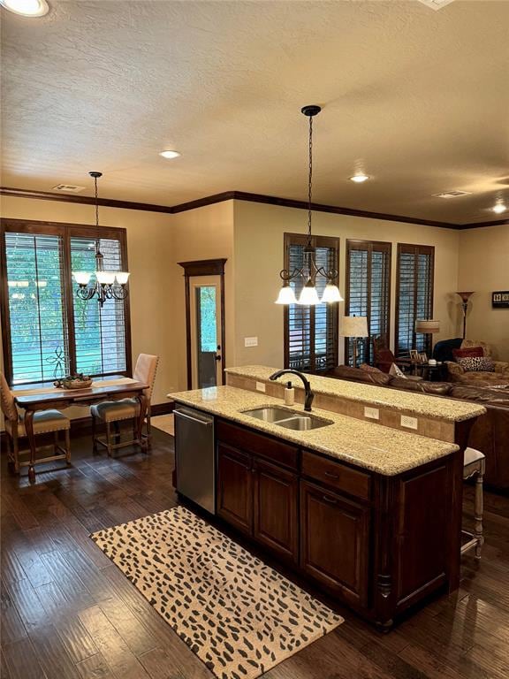 kitchen with sink, dark wood-type flooring, stainless steel dishwasher, pendant lighting, and a center island with sink