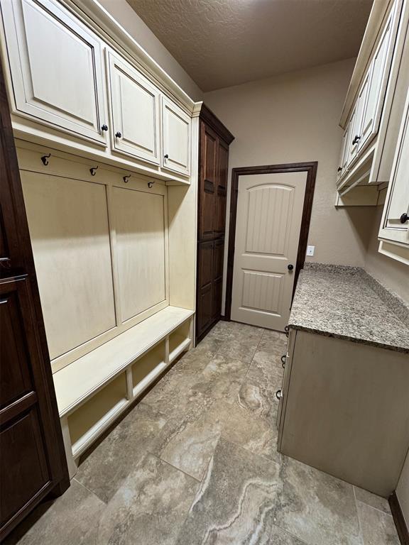 mudroom with a textured ceiling