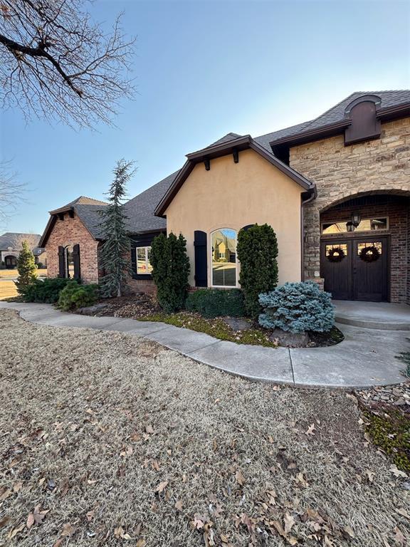 view of front of home with stucco siding and stone siding