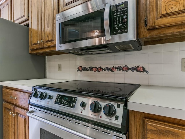 kitchen featuring stainless steel appliances and tasteful backsplash