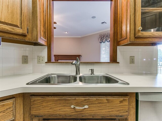 kitchen with tasteful backsplash, plenty of natural light, crown molding, and sink