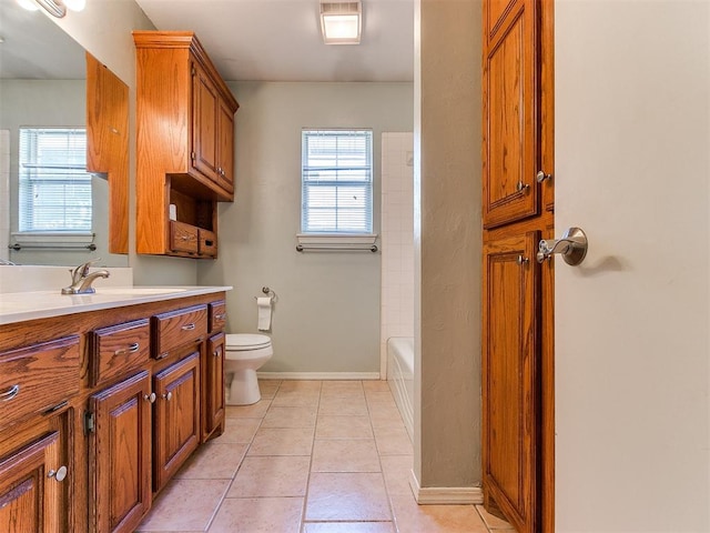 bathroom with toilet, vanity, and tile patterned floors