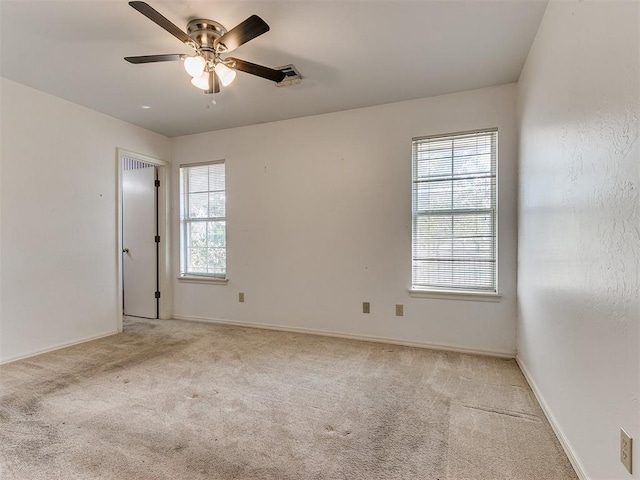 spare room featuring light carpet and ceiling fan