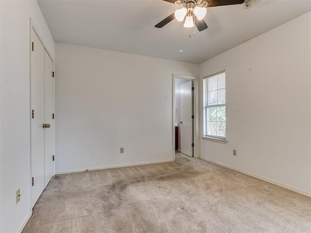 spare room featuring light carpet and ceiling fan