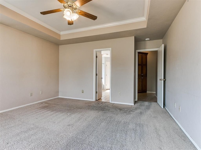 unfurnished bedroom with light colored carpet, a raised ceiling, ceiling fan, and crown molding