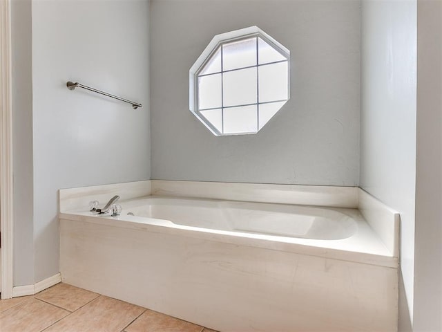 bathroom with tile patterned flooring and a bath