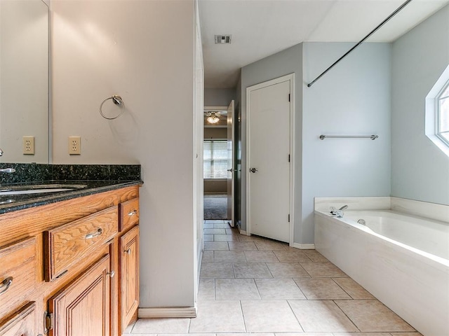 bathroom with tile patterned floors, vanity, and a tub