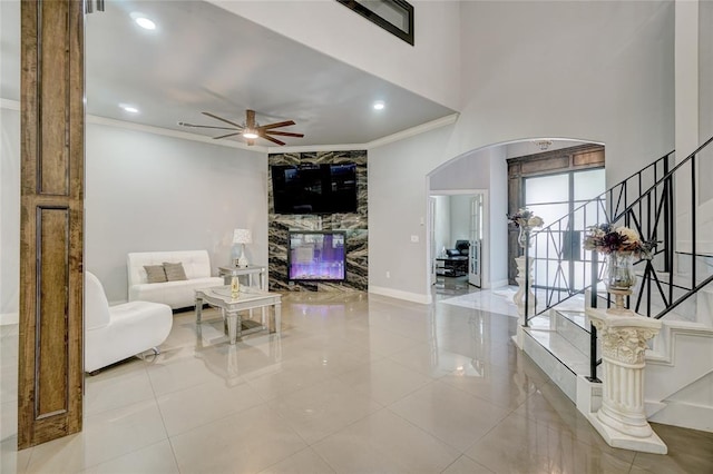 tiled living room featuring crown molding and ceiling fan