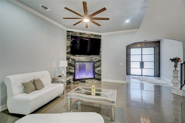 living room with light tile patterned floors, ceiling fan, and ornamental molding