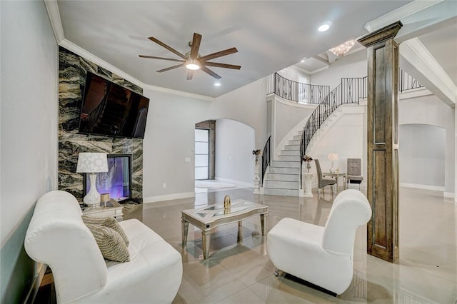 living room featuring decorative columns, ceiling fan, crown molding, and light tile patterned floors