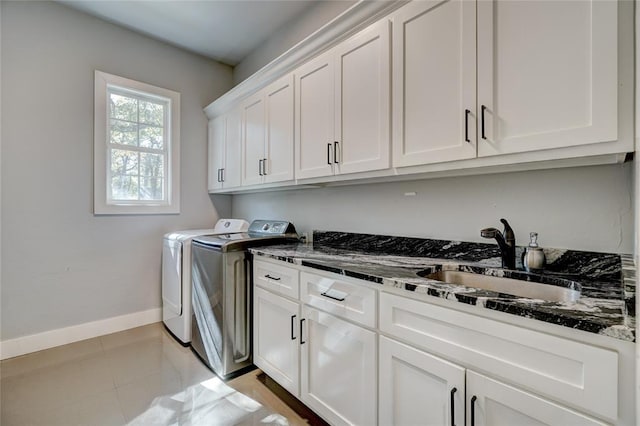 laundry room featuring separate washer and dryer, sink, light tile patterned floors, and cabinets