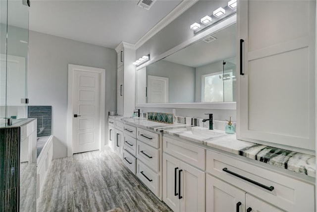 bathroom with hardwood / wood-style floors, vanity, and ornamental molding