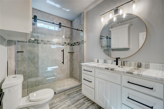 bathroom with vanity, hardwood / wood-style flooring, toilet, and a shower with shower door