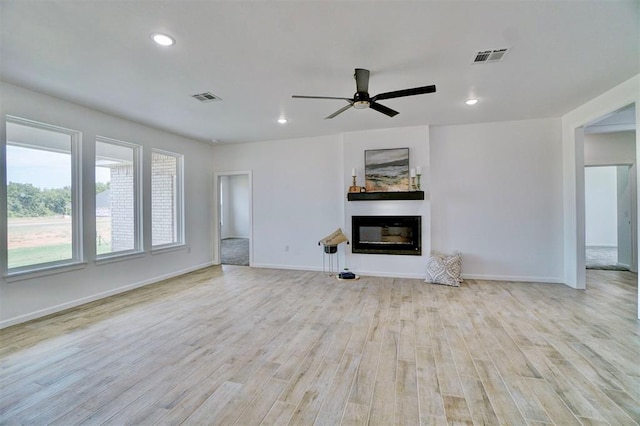 unfurnished living room featuring ceiling fan and light wood-type flooring