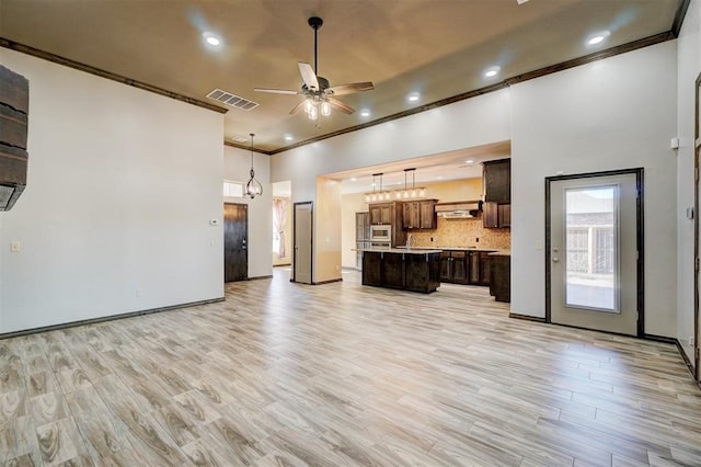 unfurnished living room with ceiling fan, ornamental molding, and light hardwood / wood-style flooring