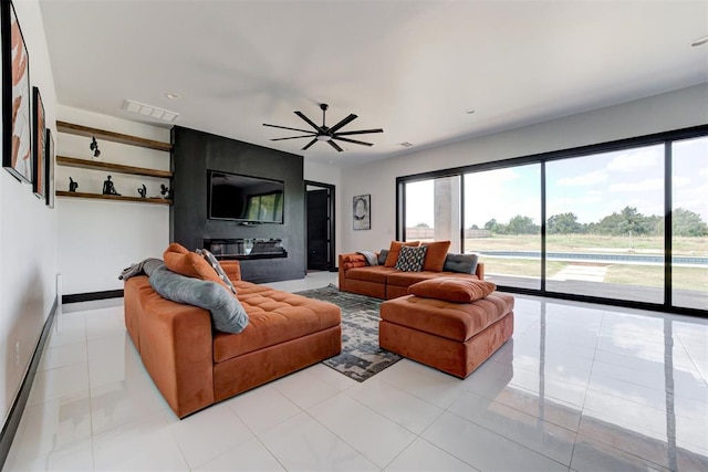 tiled living room featuring a fireplace and ceiling fan