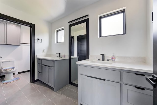 bathroom with tile patterned flooring, vanity, and toilet