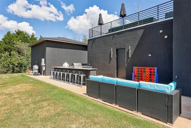 back of house with a yard, an outdoor kitchen, an outdoor bar, a balcony, and a patio