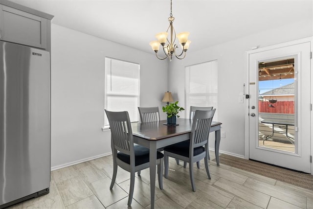 dining space with a chandelier and baseboards