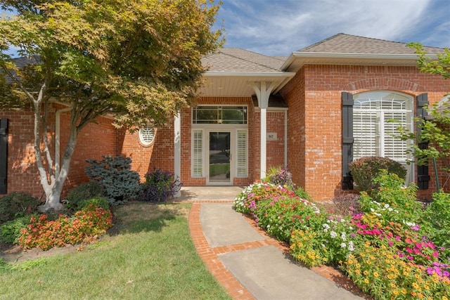 view of exterior entry with a lawn