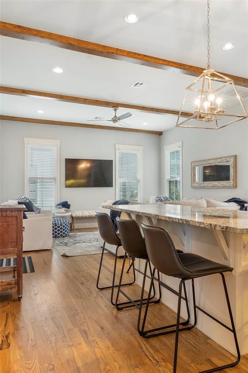 dining area with light hardwood / wood-style flooring and ceiling fan with notable chandelier