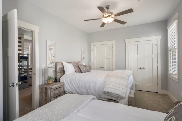 bedroom featuring carpet floors, two closets, and ceiling fan