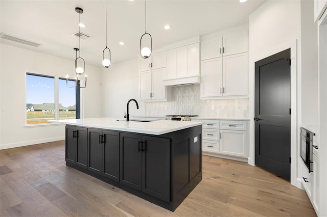 kitchen with visible vents, white cabinetry, and decorative backsplash