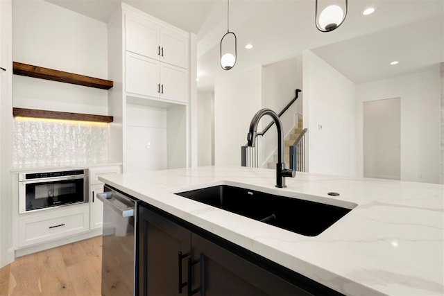 kitchen featuring light stone countertops, open shelves, appliances with stainless steel finishes, white cabinetry, and decorative light fixtures