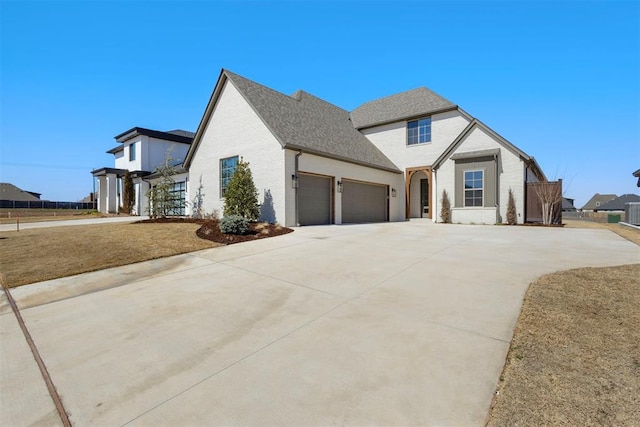 view of front facade featuring an attached garage, brick siding, driveway, and roof with shingles