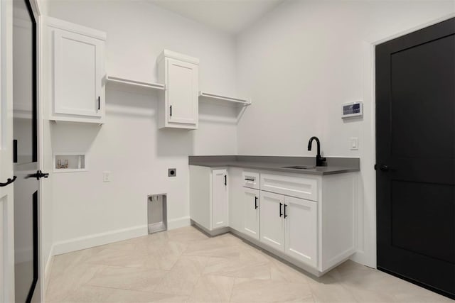 clothes washing area featuring baseboards, cabinet space, electric dryer hookup, washer hookup, and a sink