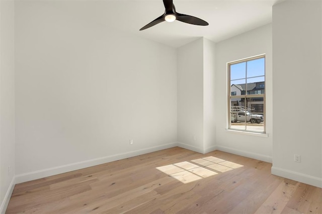 unfurnished room featuring baseboards, light wood-style floors, and ceiling fan