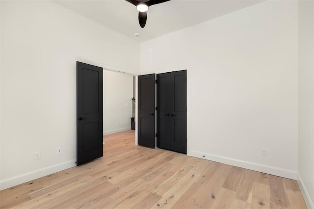 unfurnished room featuring baseboards, light wood-type flooring, and ceiling fan