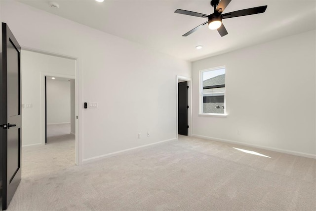 unfurnished bedroom with ceiling fan, baseboards, and light carpet