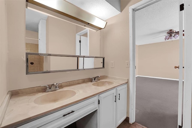 bathroom featuring ceiling fan, a textured ceiling, and vanity