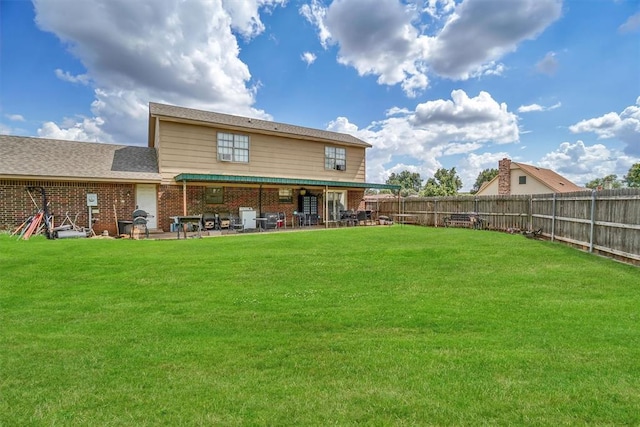 back of house with a patio area and a yard