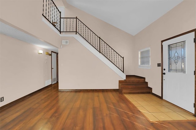 foyer featuring high vaulted ceiling and light hardwood / wood-style floors