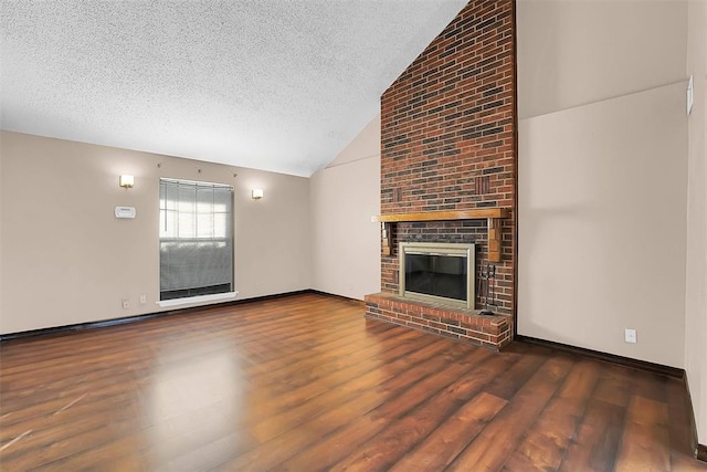 unfurnished living room featuring dark hardwood / wood-style floors, a textured ceiling, and a brick fireplace