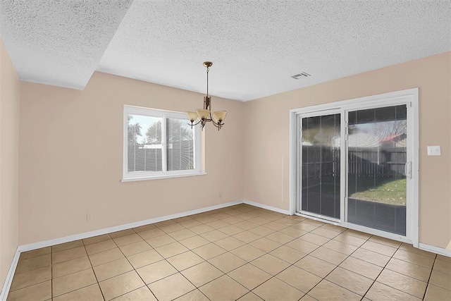 unfurnished dining area featuring light tile patterned floors, a textured ceiling, and a notable chandelier