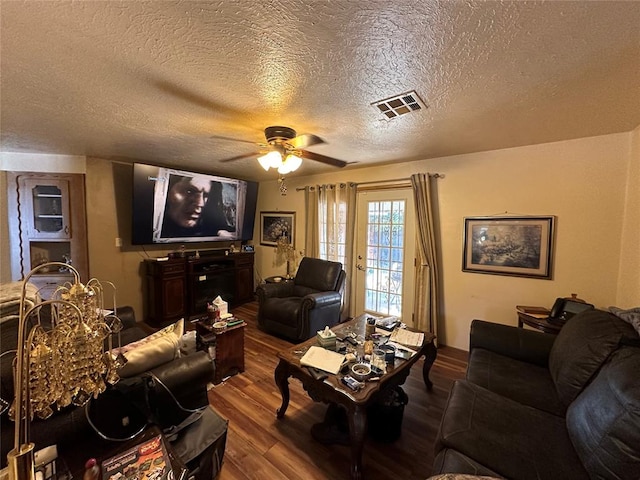 living room featuring ceiling fan, a textured ceiling, and hardwood / wood-style flooring