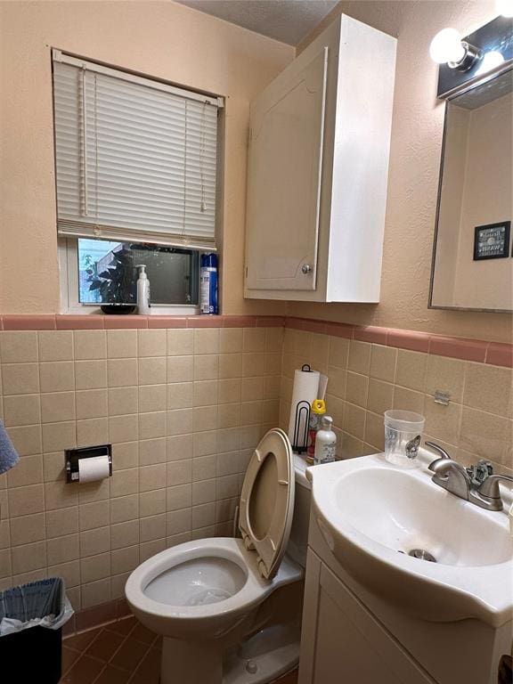 bathroom with tile patterned floors, vanity, tile walls, and toilet