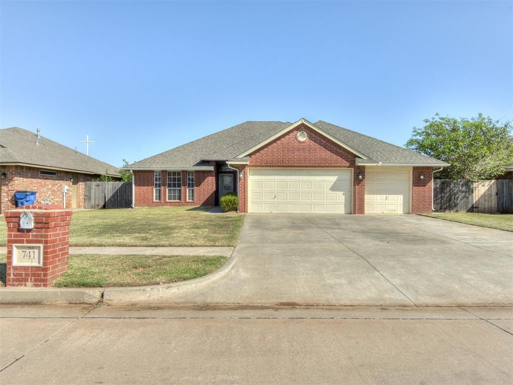 ranch-style home featuring a garage and a front lawn