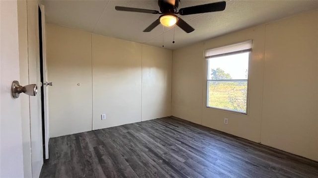 unfurnished room featuring ceiling fan and dark wood-type flooring