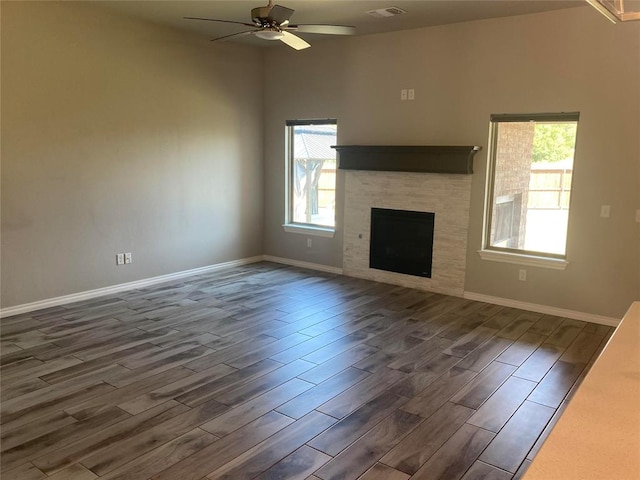 unfurnished living room with plenty of natural light, ceiling fan, and dark hardwood / wood-style flooring