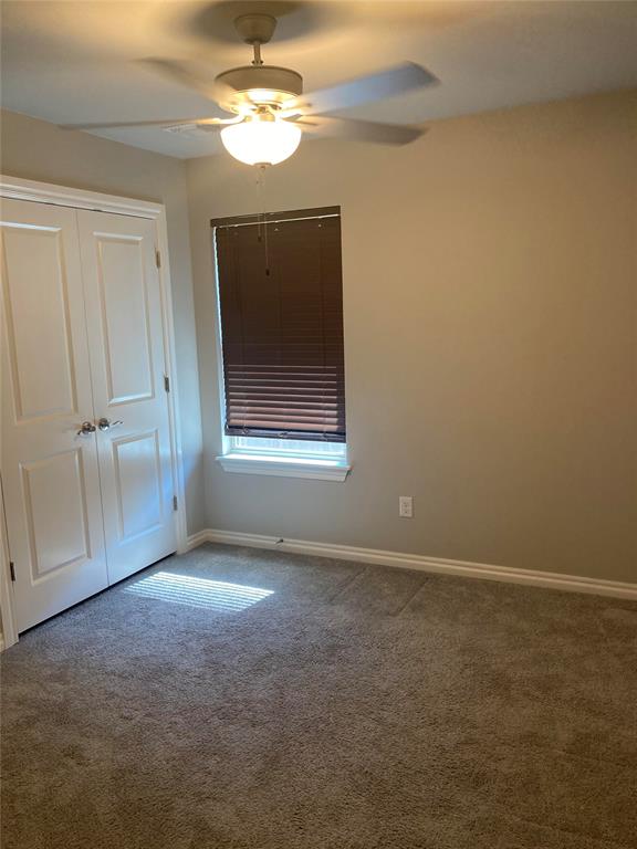 carpeted spare room with ceiling fan