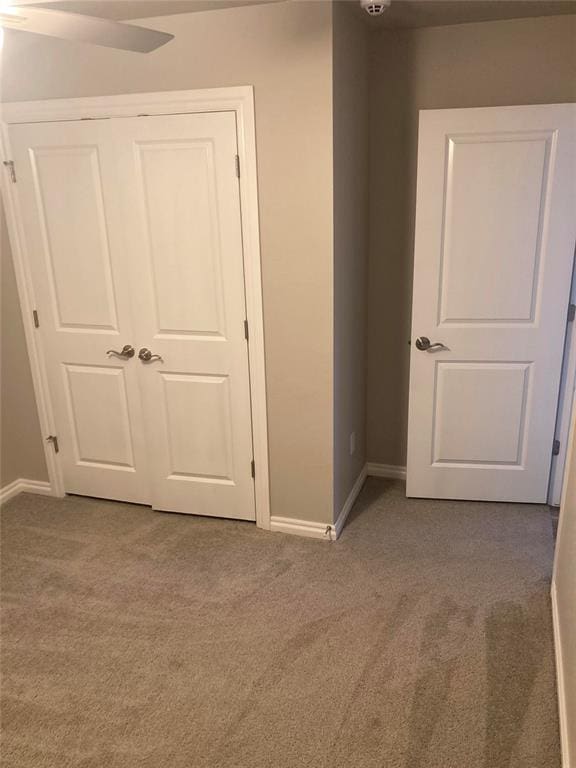 unfurnished bedroom with carpet, a closet, and ceiling fan