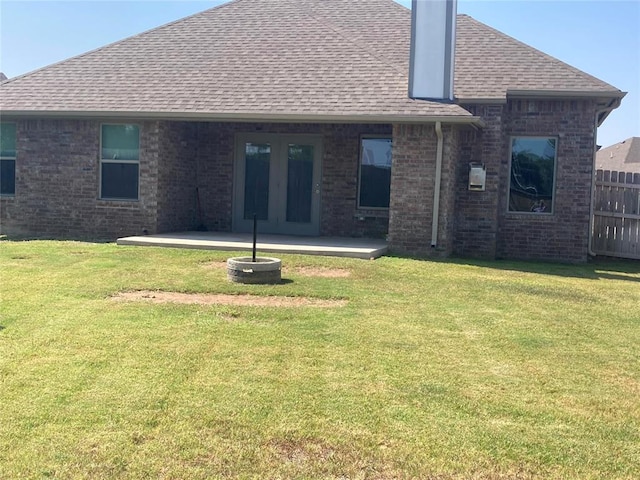 back of property with a lawn and a patio