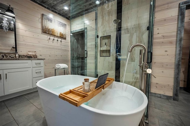 bathroom with tile patterned flooring, vanity, wood walls, and shower with separate bathtub