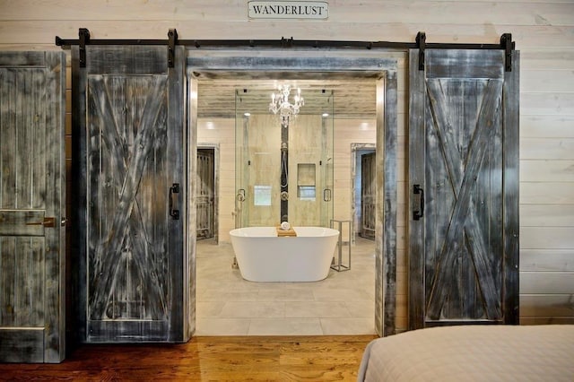 bathroom with hardwood / wood-style floors, wood walls, and a bathing tub