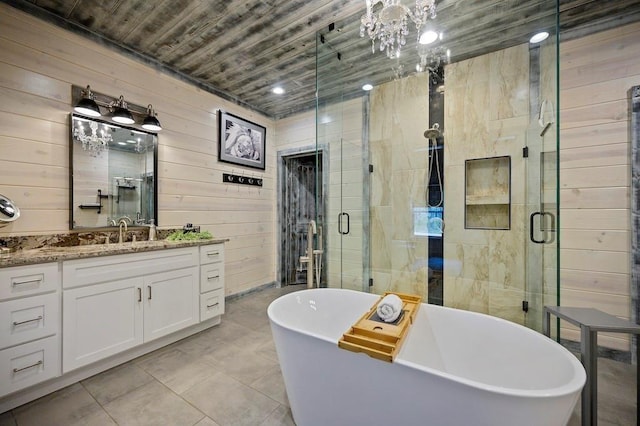 bathroom with plus walk in shower, vanity, tile patterned floors, and wooden walls